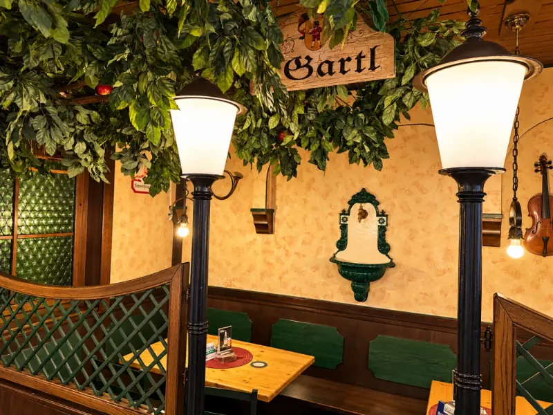 Nische „Gartl“ mit schmiedeeisernen Laternen, Wandbrunnen und Weinranken