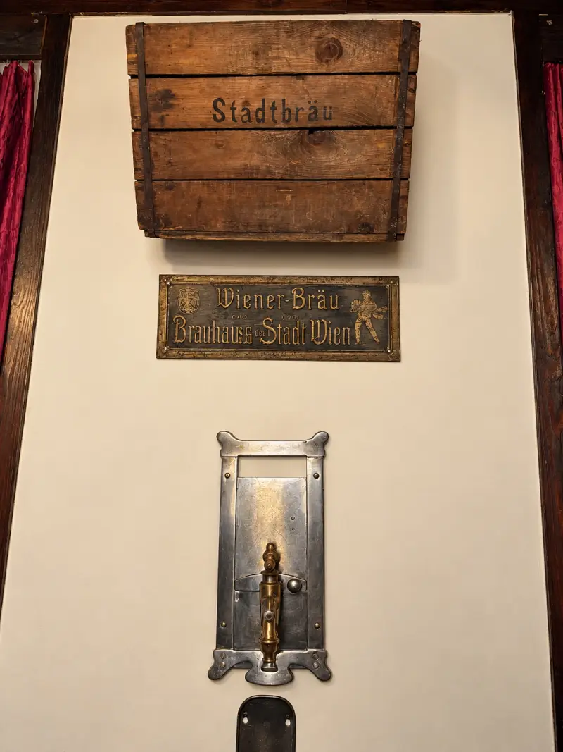 Alte Bierkiste „Städtbräu“, Messingschild „Wiener Bräu — Brauhaus Stadt Wien IX“ und ein Zapfhahn an der Wand
